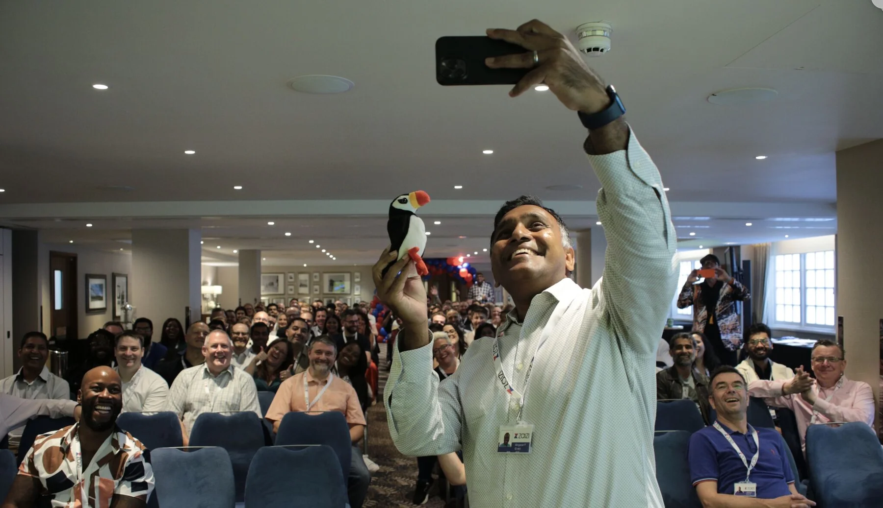A Zaizi event participant takes a selfie with the audience.