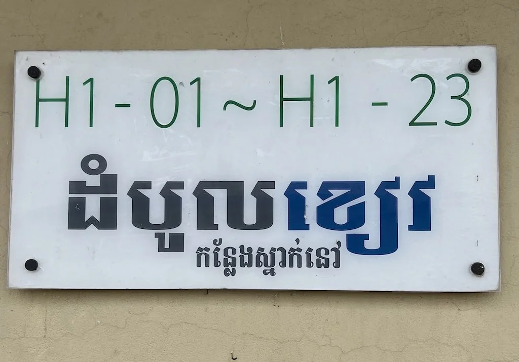 A worker accommodation sign with Khmer text.