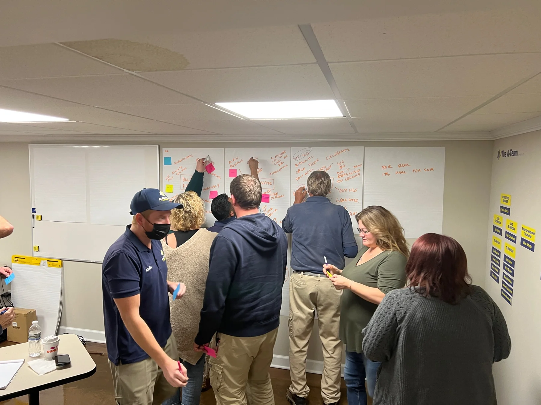 A-Action Pest Control team members gather around a workshop board.