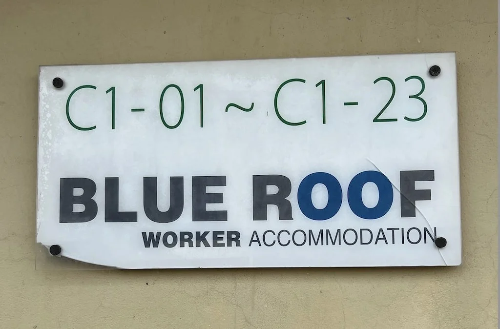 A sign reading “Blue Roof Worker Accommodation.”