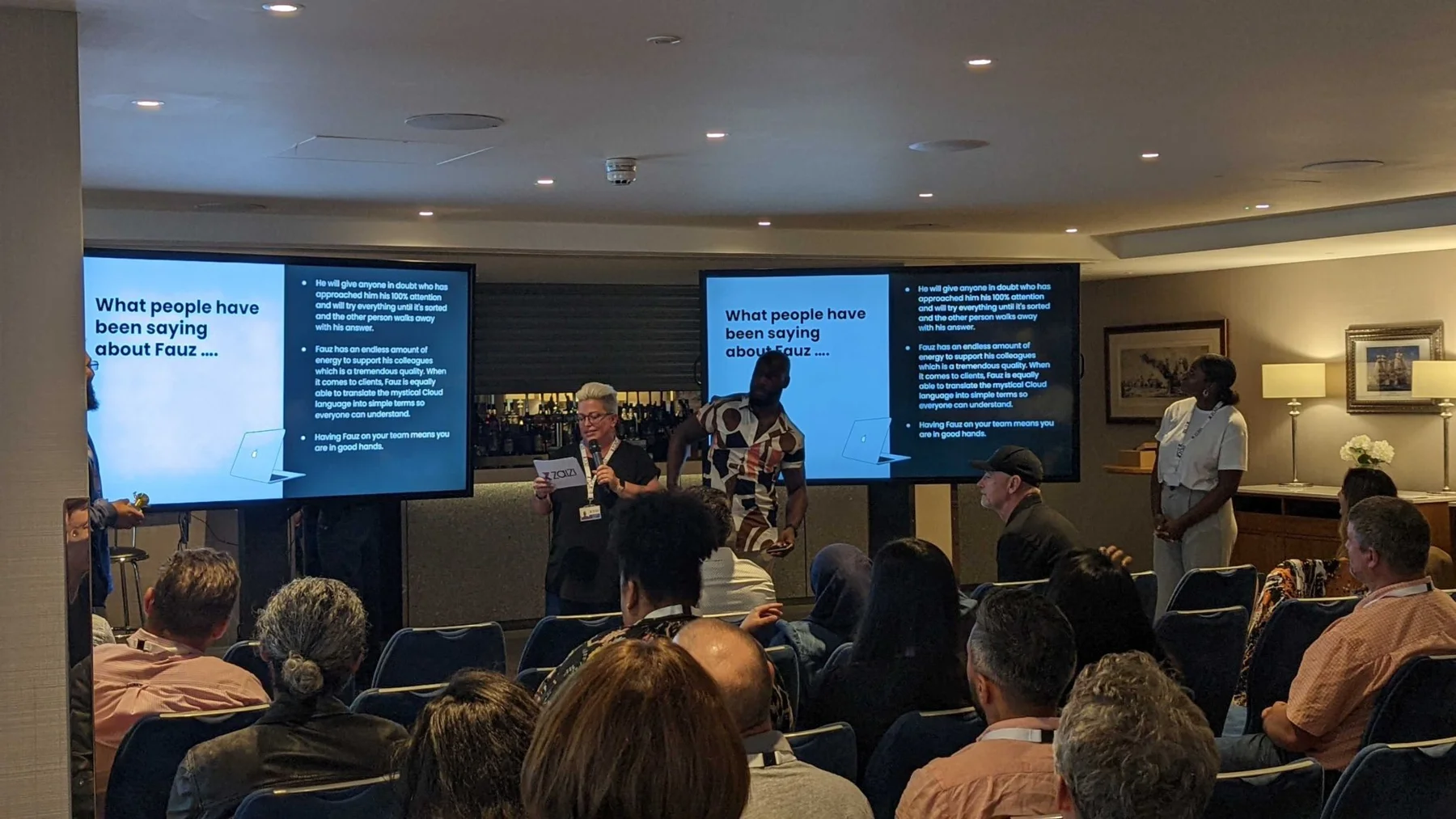 A presenter leads a Zaizi culture session in front of a seated audience.