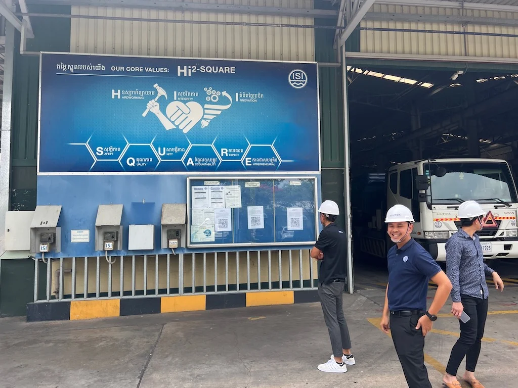 Visitors stand beside a factory’s culture display board.